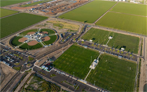 Aerial view of Legacy Fields sports complex in Tracy, showing multiple soccer fields, baseball diamonds, parking lots, and surrounding agricultural land.