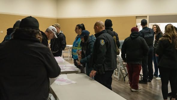 Community volunteers and staff gather around tables at the Tracy Community Center to receive instructions and materials for the annual Point-in-Time Count of individuals experiencing homelessness.