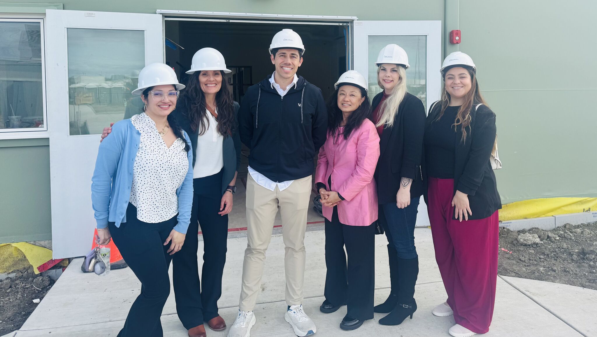 City staff and representatives from Ruby’s Place (Restorative Pathways) wear hard hats while visiting the Temporary Emergency Housing Facility during construction of the shelter campus expansion.