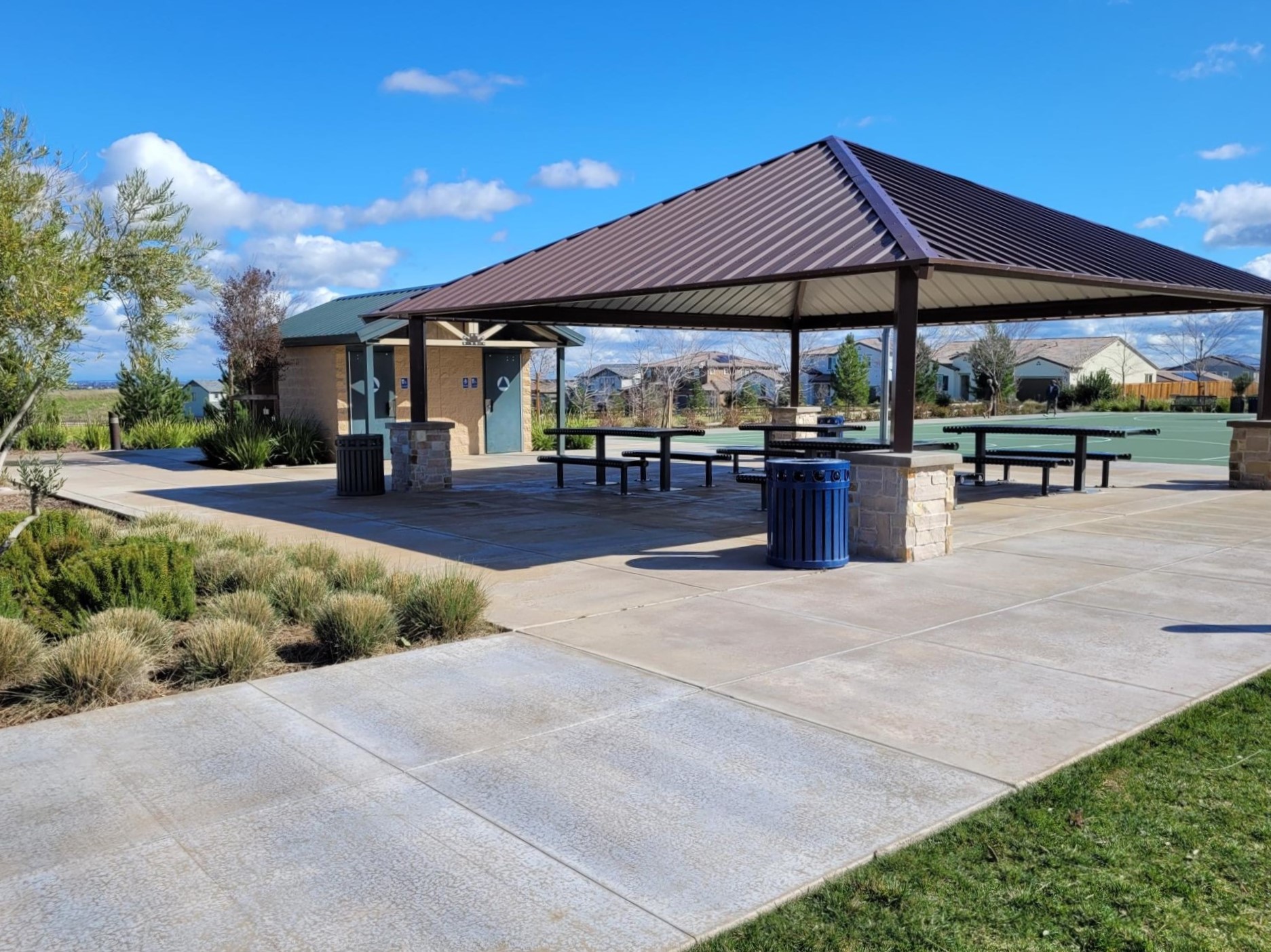 Local park with a covered picnic area adjoining the space with a basketball court and restrooms