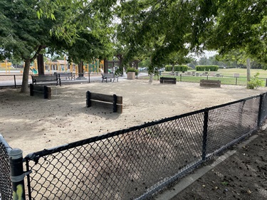 Horseshoe courts with benches and shaded open space beneath mature trees.