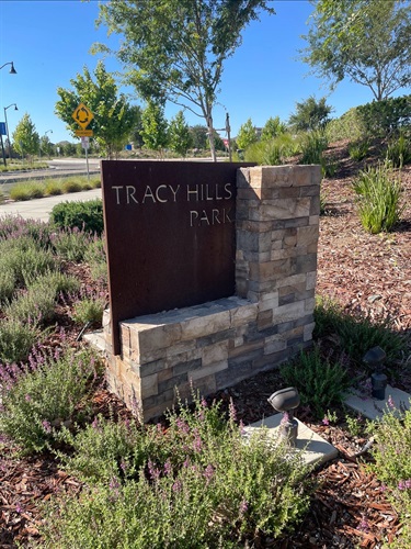 Stone and weathered steel entrance sign displaying 