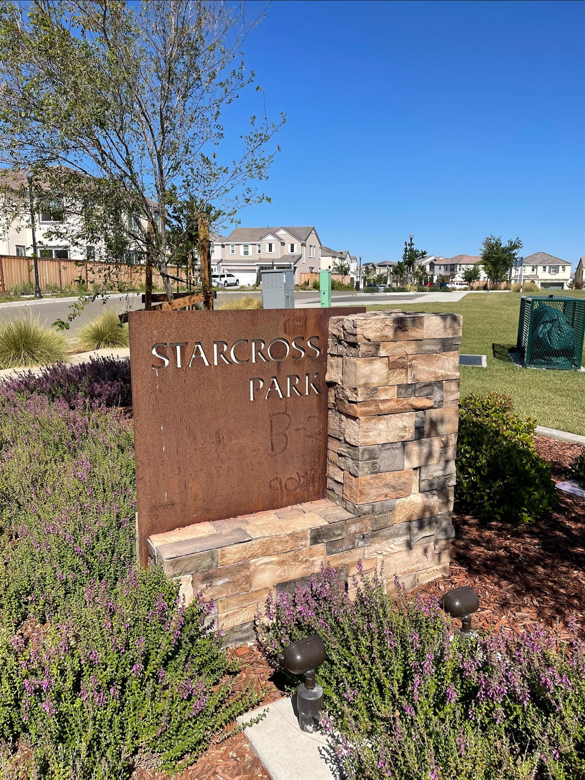 Stone and weathered steel entrance sign displaying 