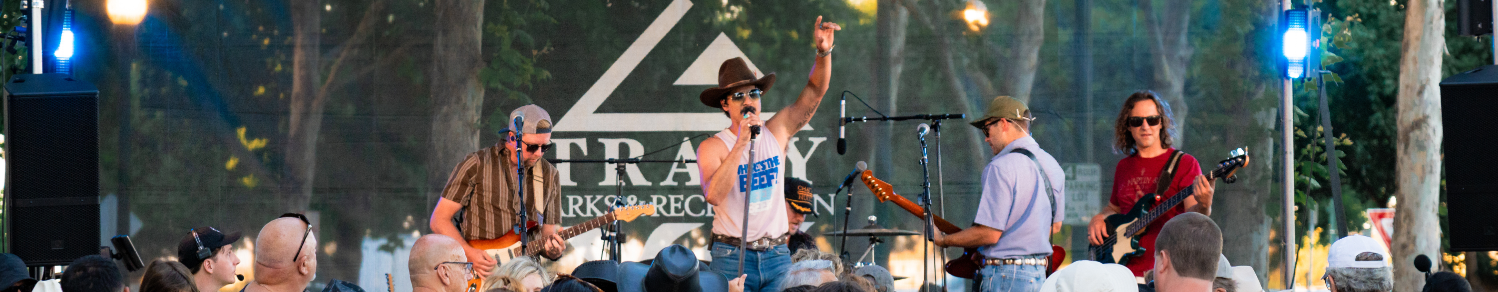 Man signing on stage with arm up